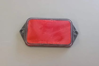 03034 - Catadiottro rosso, bordo nero forato,interforo mm 110